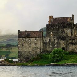 Historic Eilean Donan Castle on grassy shores by the water